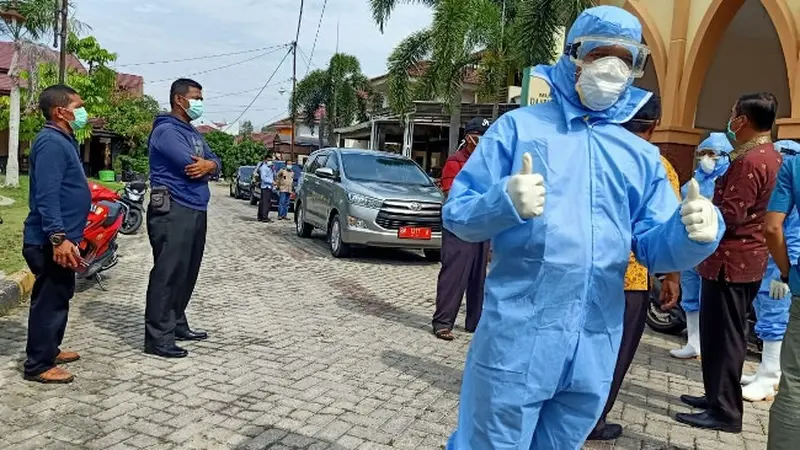 Petugas medis memakai APD melakukan sterilisasi di sebuah wilayah yang diduga ada warga gejala virus corona.