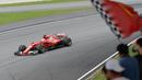 Pebalap Ferrari, Sebastian Vettel melintasi jalur dengan dukungan suporter pada balapan Formula One Malaysia Grand Prix, Sepang, (01/10/2017). Vettel akhirnya finis pada posisi keempat. (AFP/Roslan Rahman)