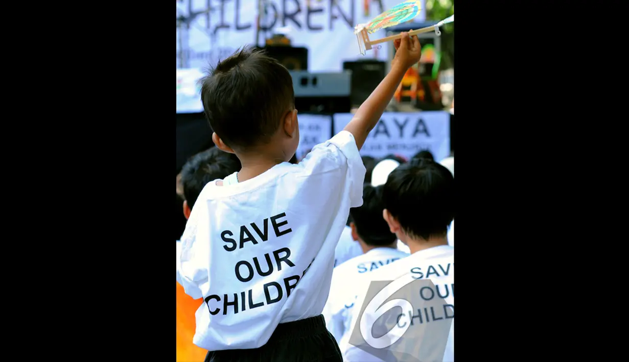 Seorang bocah asyik bermain dengan pesawat kayu di acara "Save Our Children", Jakarta, Minggu (23/11/2014) (Liputan6.com/Faisal R Syam)