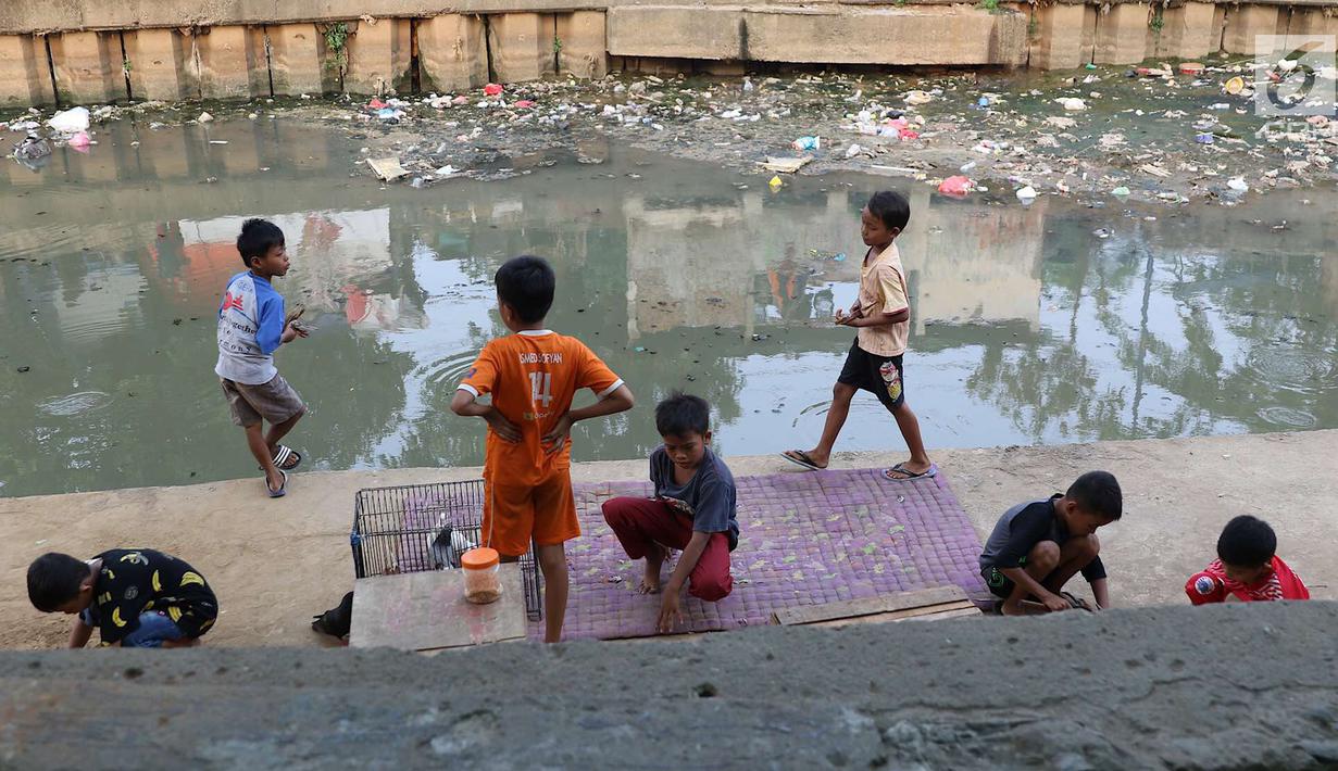 Anak-anak bermain di bantaran anak Sungai Ciliwung, Jakarta, Rabu (6/6). Meskipun tidak layak sebagai tempat bermain, namun lokasi itu menjadi tempat bagi anak-anak di kawasan tersebut untuk menunggu waktu berbuka. (Liputan6.com/Immanuel Antonius)