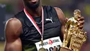 Usain Bolt berpose dengan medali yang diraihnya usai menjuarai kejuaraan atletik lari 100m Diamond League di Stadium Louis II, Monaco, (21/7). (AFP Photo/Yann Coatsaliou)