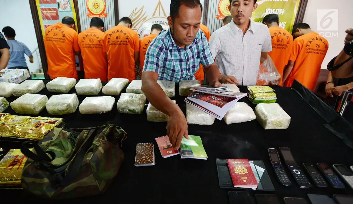 Petugas Direktorat Tindak Pidana Narkoba Mabes Polri menunjukkan barang bukti kasus peredaran sabu sindikat Aceh, Medan, dan Lombok di Jakarta, Jumat (7/12). Polisi mengamankan 12 tersangka. (Merdeka.com/Imam Buhori)