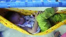 Seorang anak korban banjir tertidur setelah hujan lebat di sebuah kamp bantuan di Hyderabad, Pakistan, Selasa (6/9/2022). Pakistan sedang merasakan dampak nyata dari perubahan iklim. Banjir besar yang melanda negeri itu memicu kerugian hingga nyaris Rp 150 triliun. (AP Photo/Pervez Masih)