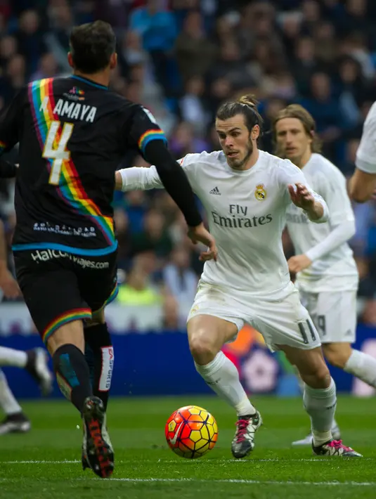Penyerang Real Madrid, Gareth Bale berusaha melewati pemain Rayo Vallecano pada lanjutan liga Spanyol di Santiago Bernabeu (20/12). Real Madrid menang telak atas Rayo Vallecano dengan skor 10-2. (AFP/curto DE LA TORRE)