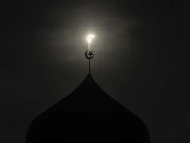 Gerhana matahari parsial di atas kubah sebuah masjid di Kuala Lumpur (9/3/2016). Gerhana matahari total terjadi di sejumlah daerah di Indonesia. (AFP Photo/Manan Vatsyayana)