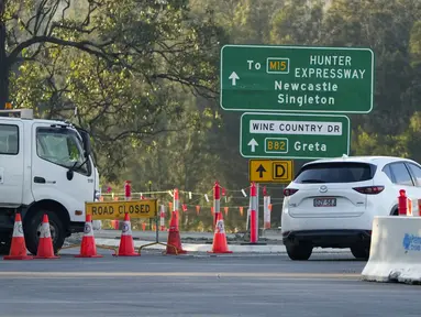 Sebuah penghalang jalan dipasang di dekat kota Greta menyusul kecelakaan bus di Hunter Valley, utara Sydney, Australia, Senin (12/6/2023). (AP Photo/Mark Baker)