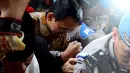Basuki Tjahaja Purnama (Ahok) berusaha menerobos kerumunan wartawan untuk menuju pintu masuk ruang pemeriksaan Mabes Polri, Jakarta, Selasa (22/11). Ahok akan diperiksa sebagai tersangka dalam kasus dugaan penistaan agama. (Liputan6.com/Johan Tallo)