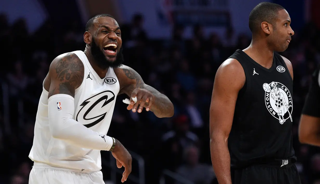 Senyum pemain tim LeBron James, LeBron James (kiri) saat bertanding dengan tim Stephen dalam NBA All Star di Los Angeles, Amerika Serikat, Minggu (18/2). Ini merupakan gelar MVP All Star ketiga dalam karier LeBron James. (AP Photo/Chris Pizzello)