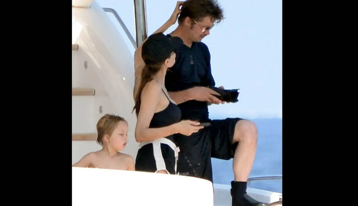Saat Brad sibuk memotret di laut, Jolie kepergok tengah membelai rambut baru suaminya, Senin (15/9/14). (Dailymail)