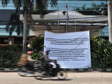 Pengendara melintas di depan banner informasi penutupan Hotel Alexis, Jakarta, Rabu (28/3). Hotel Alexis mulai hari ini resmi tidak beroperasi dengan memasang banner info penutupan di depan hotel. (Merdeka.com/Iqbal S. Nugroho)