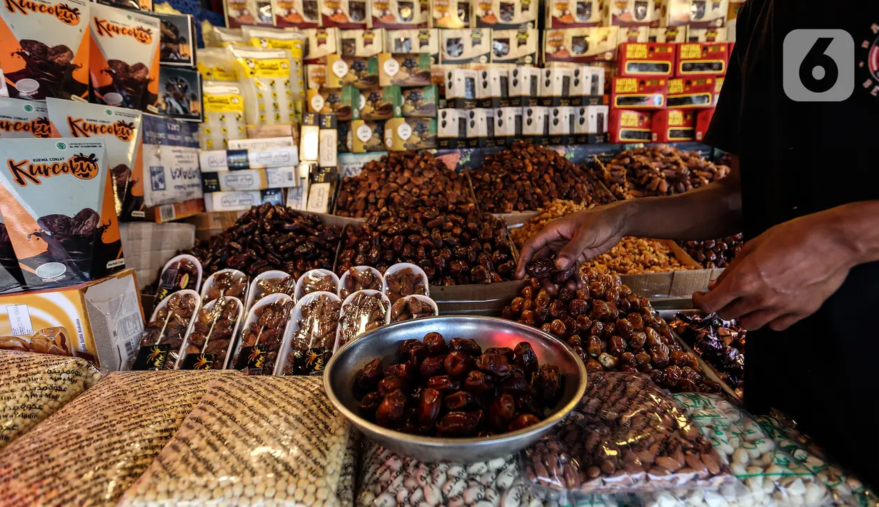 Pedagang menimbang kurma di kawasan Tanah abang, Jakarta, Minggu (3/4/2022). Omset penjualan kebutuhan bulan Ramadhan seperti perlengkapan ibadah dan buah kurma kembali meningkat dibandingkan dua tahun terakhir yang terdampak pandemi COVID-19. (Liputan6.com/Johan Tallo)