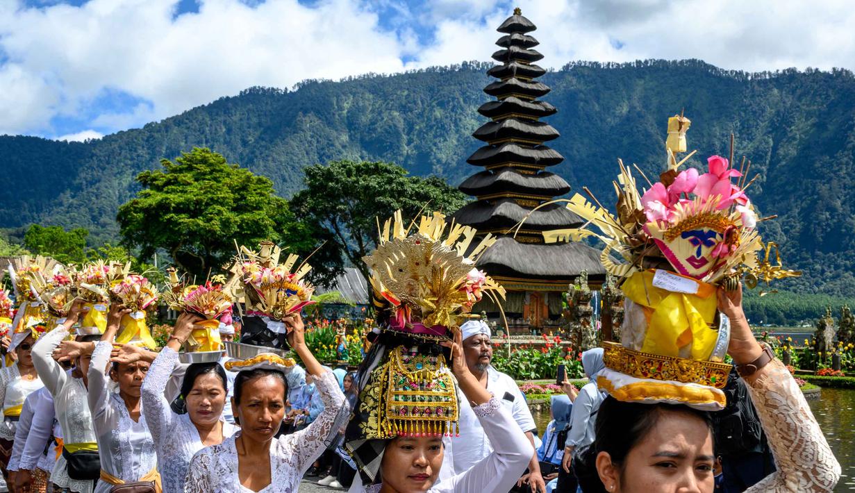 Daya tarik utama terletak pada dua pura yang paling menonjol, yakni Pelinggih Teling Segara dengan meru bertumpang 11 dan Pelinggih Linggah Ulun Danu dengan meru bertumpang tiga, yang terlihat mengambang di danau. Tampak dalam foto, umat Hindu bersiap mengikuti prosesi keagamaan di Pura Ulun Danu Beratan, sebuah pura Hindu di Danau Beratan dekat Bedugul, Bali, pada Jumat 7 November 2025. (Mladen ANTONOV/AFP)