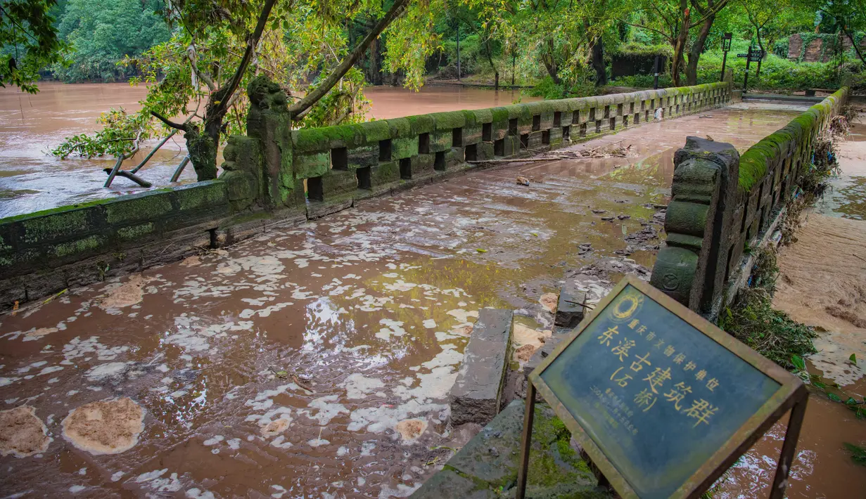 Banjir yang melanda Wilayah Dongxi di Distrik Qijiang, Kota Chongqing, China barat daya (1/7/2020). Guyuran hujan telah menyebabkan peningkatan debit air ke sungai-sungai di daerah pusat kota, dan beberapa pagar pengaman di sepanjang sungai rusak oleh derasnya arus air. (Xinhua/Chen Xingyu)