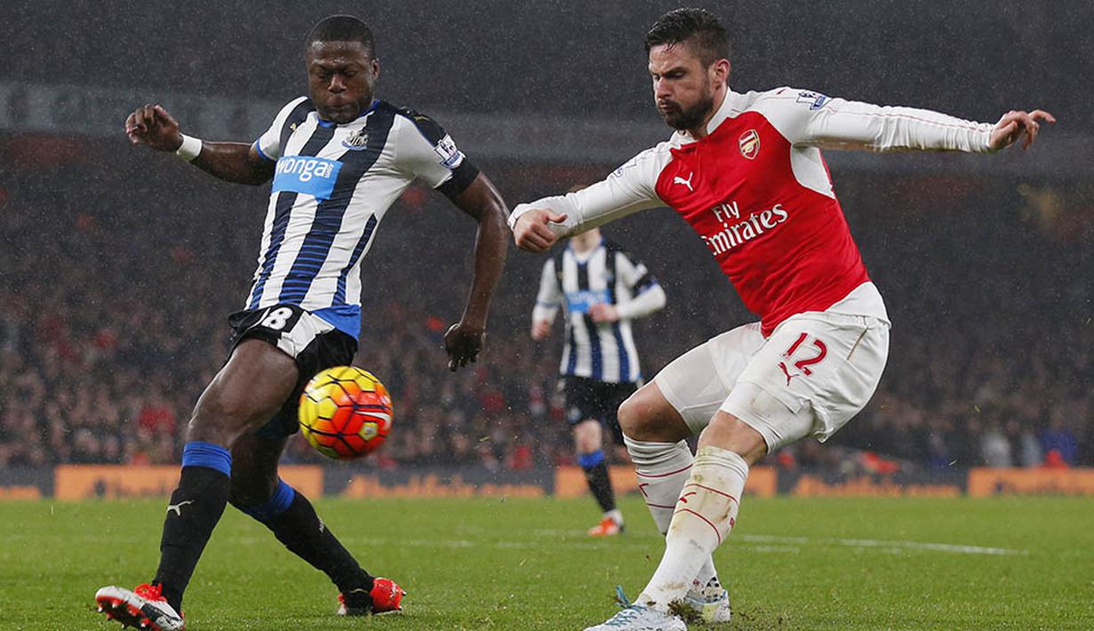 Striker Arsenal, Olivier Giroud, dihadang pemain Newcastle, Chancel Mbemba, ketika akan mengirim umpan pada laga Liga Premier Inggris. Berkat kemenangan itu Arsenla kian kokoh di puncak klasemen. (Reuters/Eddie Keogh)