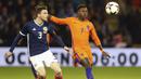 Pemain Skotlandia, Andrew Robertson (kiri) berebut bola dengan pemain Belanda, Quincy Promes pada laga persahabatan di Pittodrie, Aberdeen, Skotlandia (9/11/2017). Belanda menang 1-0. (Andrew Milligan/PA via AP)