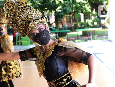 Penari tradisional dari Sanggar Eschoda melakukan latihan menggunakan masker dan pelindung wajah di Kota Tangerang, Jumat (12/6/2020). Para penari itu menerapkan protokol kesehatan jelang new normal atau tatanan hidup normal, sekaligus sebagai upaya pencegahan Covid-19. (Liputan6.com/Angga Yuniar)