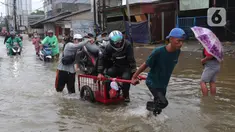 Pengendara sepeda motor menggunakan jasa angkut gerobak saat melintasi banjir yang merendam jalan KH Hasyim Ashari, Kota Tangerang, Banten, Sabtu (16/7/2022). Warga sekitar membantu para pengendara yang melintas agar tidak terkena banjir dengan menawarkan jasa gerobak. (Liputan6.com/Angga Yuniar)