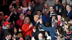 Usai resmi dilantik sebagai Presiden Amerika Serikat, Donald Trump bersama Ibu Negara Melania Trump menghadiri parade perdana di dalam Capital One Arena, Washington DC. (ANGELA WEISS/AFP)