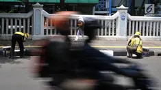 Petugas Suku Dinas Bina Marga Jakarta Timur saat menyelesaikan pengecatan trotoar di Jalan Persahabatan Raya, Jakarta, Rabu (27/3). Kegiatan pengecatan ini rutin dilakukan guna merawat sekaligus mempercantik jalur pedestrian tersebut. (merdeka.com/Iqbal S. Nugroho)