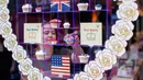 Karyawan menata cupcakes edisi khusus untuk menghormati pernikahan Pangeran Harry dan Meghan Markle di Hummingbird Bakery, London, 11 Mei 2018. Pernikahan Harry dan Meghan digelar 19 Mei mendatang di Kapel St. George, Istana Windsor. (AFP/Tolga AKMEN)