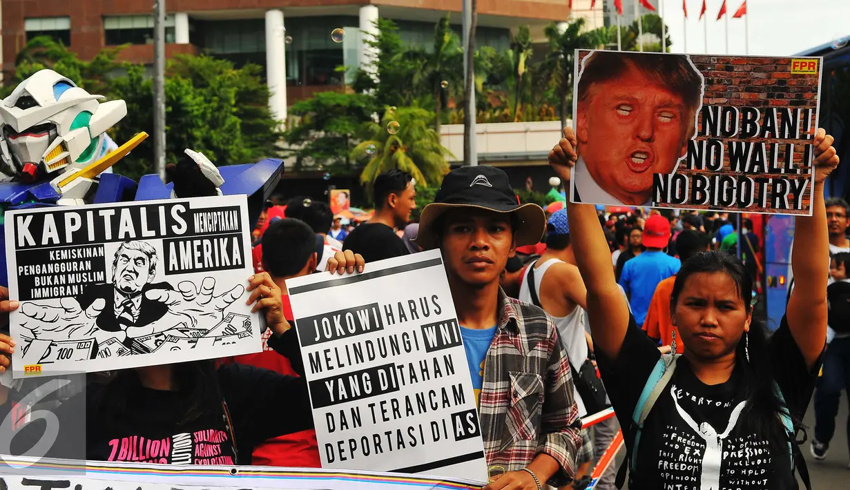 Sejumlah masa yang tergabung dalam front Perjuangan Rakyat membawa poster saat melakukan aksi yang mengecam kebijakan Presiden Amerika Serikat Donald Trump di Jakarta, Minggu (5/2). (Liputan6.com/Angga Yuniar)