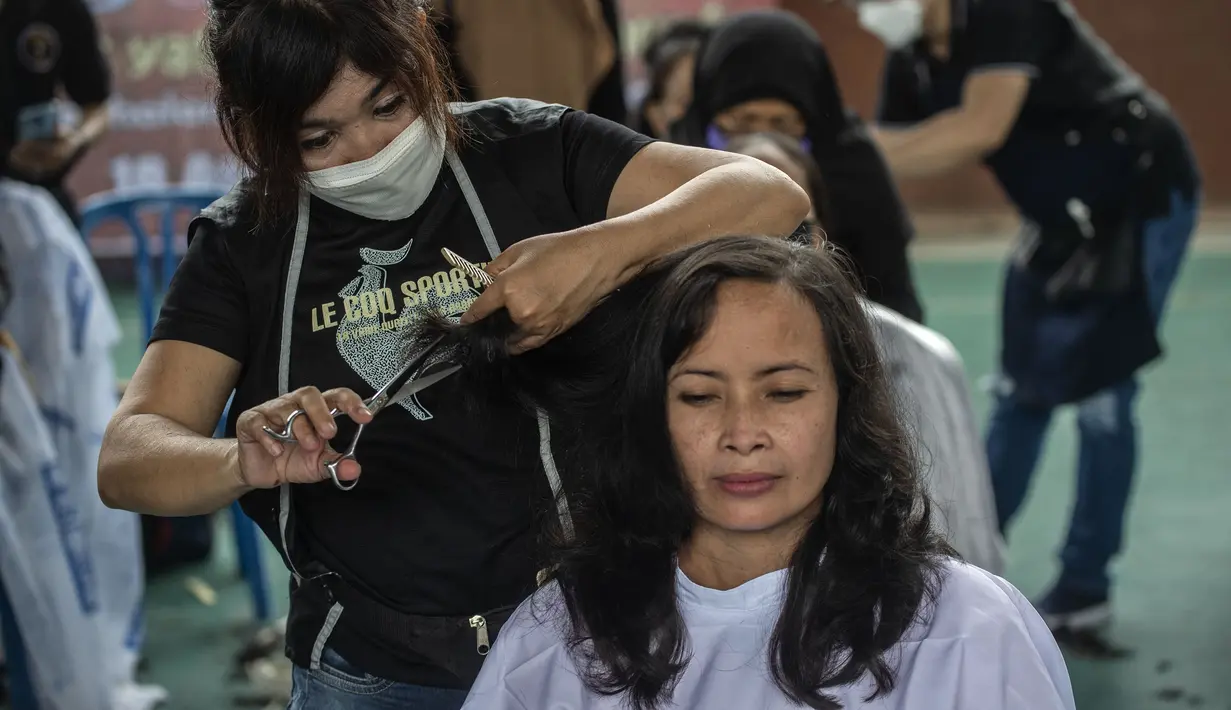 Warga saat potong rambut gratis di Masjid Muhammad Cheng Hoo, Surabaya, Jawa Timur, Senin (18/4/2022). Kegiatan berbagi dalam bulan Ramadhan yang digelar Baksose Suroboyo dan Ngaji Komunitas Salon (Ngasal) Surabaya itu diikuti sekitar 450 orang. (AFP/Juni Kriswanto)