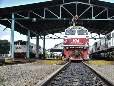 Petugas saat mencuci lokomotif kereta jarak jauh di Depo KA Cipinang, Jakarta Timur, Selasa (6/9/2022). Depo Kereta Cipinang merupakan fasilitas perawatan kereta terbesar di Indonesia yang berfungi sebagai tempat pemantauan kelayakan lokomotif dan gerbong sebelum beroperasi. (merdeka.com/Iqbal S Nugroho)