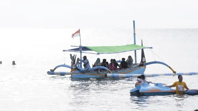 Wisatawan nampak asik bermain kano dan naik perahu wisata di Pantai Pasir Putih Situbondo. (Istimewa)