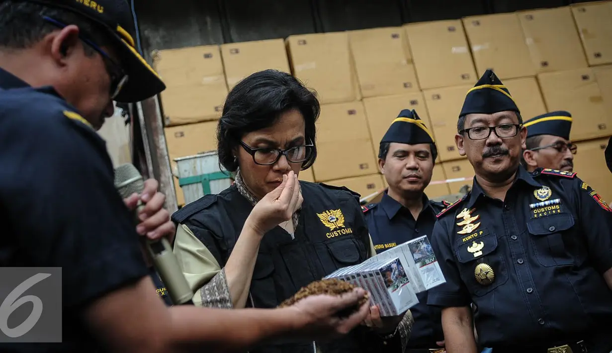 Menteri Keuangan Sri Mulyani mencium tembakau rokok ilegal di Kantor Dirjen Bea Cukai, Jakarta, Jumat (30/9). Sri Mulyani mengaku takjub dengan temuan rokok ilegal yang sudah terkemas rapi. (Liputan6.com/Faizal Fanani)
