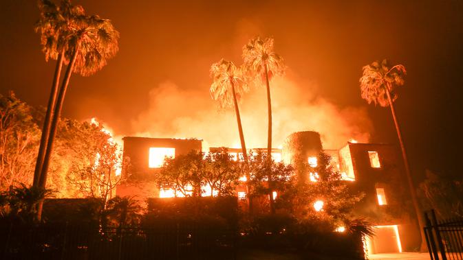 Kobaran api membakar sebuah rumah di Malibu, California, AS, Jumat (9/11). Departemen Pemadam Kebakaran setempat mendesak agar warga segera mengungsi ke tempat aman. (AP Photo/Ringo H.W. Chiu)