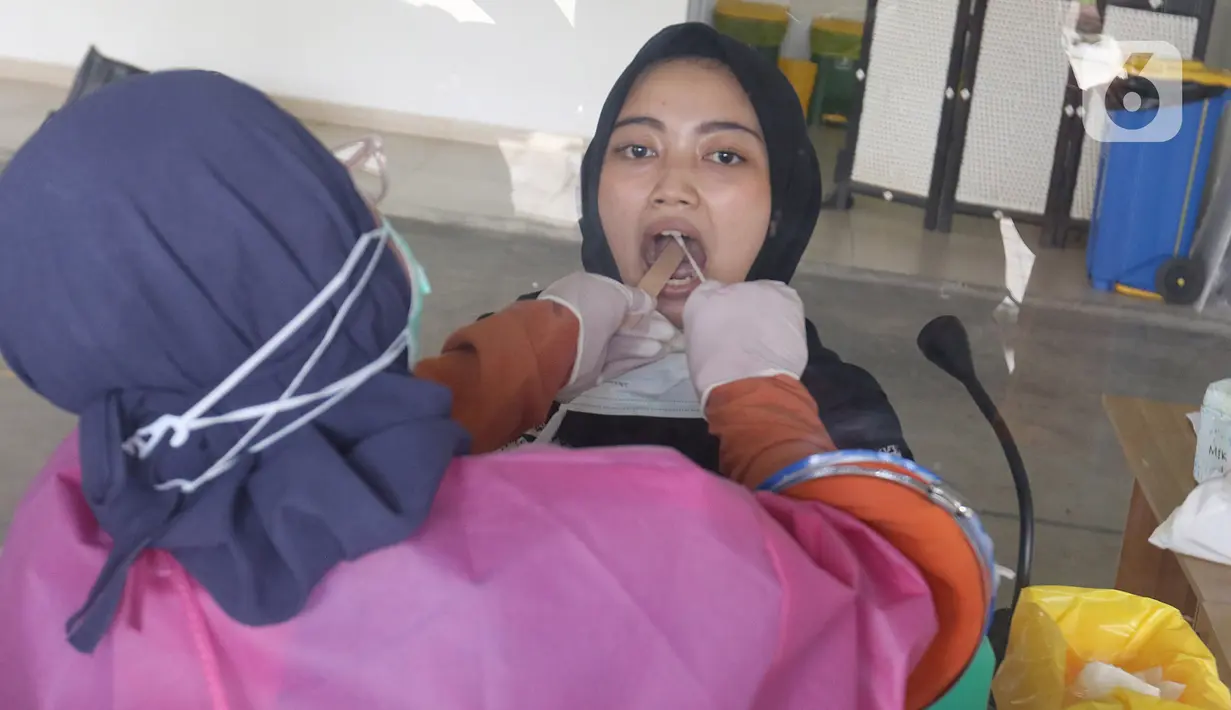 Petugas medis melakukan swab test terhadap warga di Rumah Sakit Universitas Indonesia (RSUI), Depok, Jawa Barat, Selasa (2/6/2020). Pemerintah Kota Depok mensubsidi dengan menggratiskan warganya yang mengikuti program pekan swab test massal di RSUI. (Liputan6.com/Herman Zakharia)