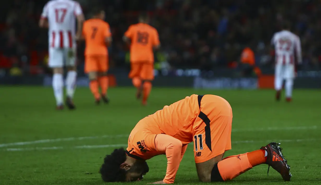 Gelandang Liverpool, Mohamed Salah, sujud merayakan gol yang dicetaknya ke gawang Stoke pada laga Premier League di Stadion Bet365, Stoke-on-Trent, Rabu (29/11/2017). Stoke kalah 0-3 dari Liverpool. (AFP/Geoff Caddick)