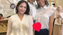 Nagita Slavina hadir mengenakan atasan knit pleated berkancing putih dipadukan celana hitam sambil membawa tas Hermes merah. [@bungajelitha66]