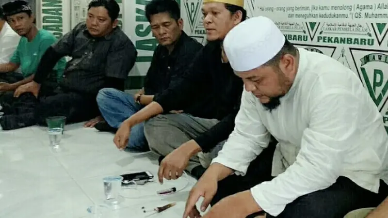 Joni Boy (tengah) ketika dibawa FPI Pekanbaru setelah menghina UAS