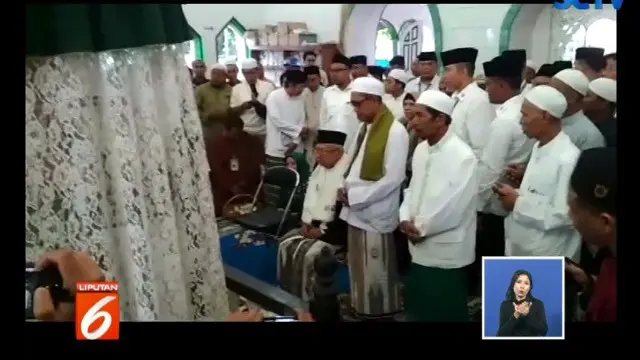 Ma'ruf tampak duduk di depan jemaah lain yang duduk bersila mengelilingi sekitar makam.