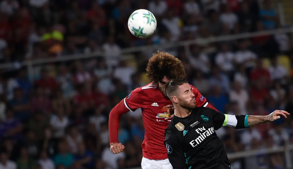 Gelandang Manchester United (MU), Marouane Fellaini berusaha menyundul bola dalam laga Piala Super Eropa melawan Real Madrid di Macedonia, Selasa (8/8). Madrid keluar sebagai juara usai menundukkan MU dengan skor 2-1. (Nikolay DOYCHINOV / AFP)