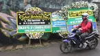 Pengendara melintas dekat karangan bunga duka cita atas meninggalnya KH Salahuddin Wahid atau Gus Sholah di rumah duka Mampang Prapatan, Jakarta, Senin (3/2/2020). Ulama yang juga adik kandung Presiden ke-4 RI Gus Dur itu meninggal dunia pada hari Minggu (2/2/2020). (Liputan6.com/Herman Zakharia)