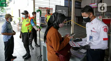 Petugas membantu calon penumpang memindai kode batang (QR Code) melalui aplikasi PeduliLindungi sebelum menaiki KRL di Stasiun Manggarai, Jakarta, Selasa (7/9/2021). PT KAI Commuter melakukan uji coba penggunaan aplikasi PeduliLindungi bagi pengguna KRL di 11 stasiun. (Liputan6.com/Faizal Fanani)