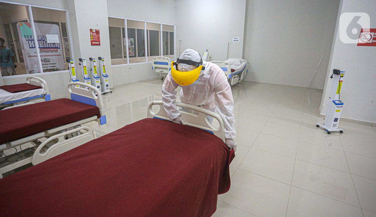 Petugas mengenakan hazmat saat menyiapkan tempat tidur di Tower 8 Wisma Atlet Pademangan, Jakarta, Selasa (15/6/2021). Tower 8 Wisma Atlet Pademangan bisa menampung 1.569 pasien untuk isolasi. (Liputan6.com/Faizal Fanani)