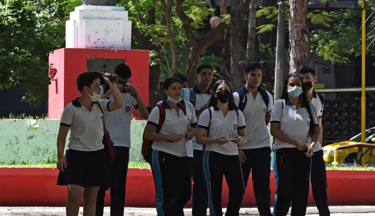 Siswa berjalan melintasi alun-alun di Asuncion (22/2/2022). Pemerintah Paraguay mengumumkan pada Selasa (22/2) bahwa mereka mencabut semua pembatasan sanitasi terkait pandemi COVID-19, kecuali untuk penggunaan masker di dalam ruangan dan di tempat ramai. (AFP/Norberto Duarte)