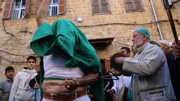 Warga muslim Sufi menusukkan benda tajam ke perutnya saat perayaan Maulid Nabi Muhammad SAW di Sidon, Lebanon (30/11). Tradisi yang mirip debus ini menjadi budaya kaum Sufi Lebanon saat memperingati Maulid Nabi. (AFP Photo/Mahmoud Zayyat)