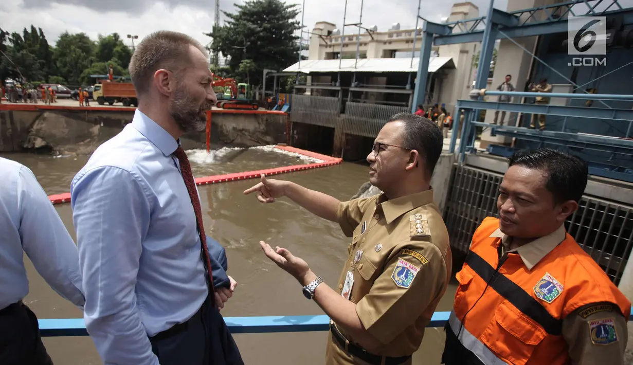 Gubernur DKI Jakarta Anies Baswedan berbincang dengan Duta Besar Norwegia Vegard Kaale saat melakukan kunjungan ke Pintu Air Manggarai, Jakarta, Selasa (30/1). (Liputan6.com/Arya Manggala)