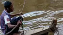 Tukang perahu eret tampak sedang menunggu penumpang di atas perahu tuanya di sungai Ciliwung, Manggarai, Jakarta, Kamis (24/4/14). (Liputan6.com/Faizal Fanani)