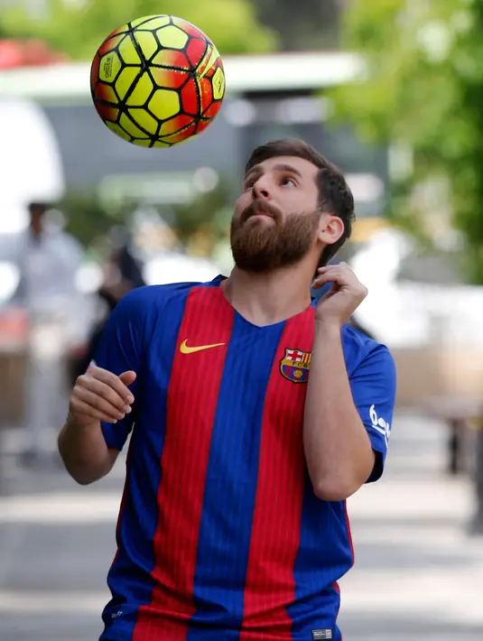 Pemuda asal Iran, Reza Parastesh menunjukkan kemampuannya mengolah bola di sebuah jalan di Teheran, Senin (8/5). Kembaran Lionel Messi itu hampir dipenjara pekan lalu karena kehadirannya menciptakan sebuah kerumunan massa di Hamedan. (ATTA KENARE/AFP)