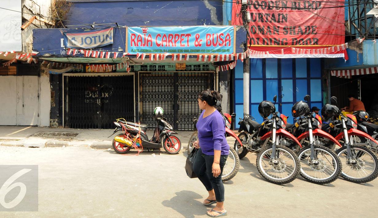 Warga melintas di depan toko yang ada di Jalan Jatinegara Barat, Jakarta, Jumat (21/8/2015). Jalan Jatinegara Barat ditutup terkait proses penggusuran warga yang tinggal di sekitar bantaran Kali Ciliwung di Kampung Pulo. (Liputan6.com/Helmi Fithriansyah)