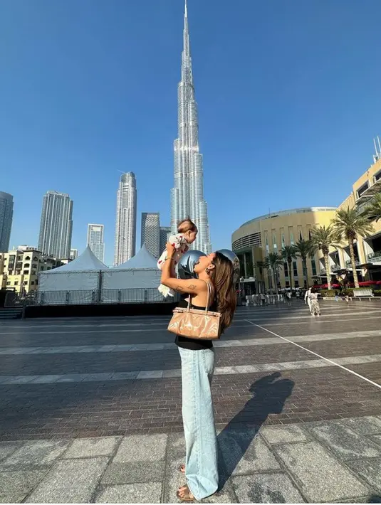 Berlibur ke Dubai, sambil menggendong anaknya, Jennifer Coppen tampil mengenakan atasan hitam dipadukan celana denim panjang. Sambil membawa shoulder bag coklatnya. [@jennifercoppenreal20]