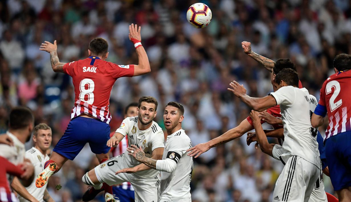 Bek Real Madrid, Nacho Fernandez, duel udara dengan gelandang Atletico Madrid, Saul Niguez, pada laga La liga di Stadion Santiago Bernabeu, Madrid, Sabtu (29/9/2018). Kedua klub bermain imbang 0-0. (AFP/Oscar Del Pozo)
