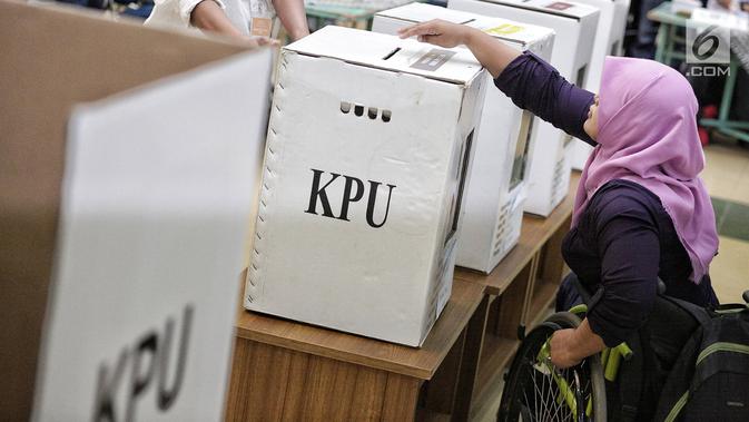 Penyandang disabilitas memasukkan surat suara ke dalam kotak saat simulasi Pemilu di Jakarta, Kamis (14/2). KPU menyediakan sejumlah fasilitas di TPS untuk penyandang disabilitas. (Liputan6.com/Faizal Fanani)