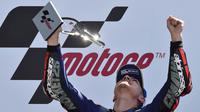 Pebalap Movistar Yamaha, Maverick Vinales, tampak gembira mengangkat piala merayakan gelar juara MotoGP Prancis. (AFP/Jean-Francois Monier) 