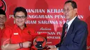 Sekjen PDI Perjuangan Hasto Kristiyanto (kiri) bertukar cinderamata dengan Ketua Sekolah Tinggi Ilmu Pemerintahan Abdi Negara (STIPAN), Tjahya Supriyatna saat penandatangan kerjasama di Jakarta, Jumat (31/7/2015). (Liputan6.com/Johan Tallo)